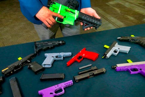 An officer with the Firearms Investigative Unit displays some of the 3D guns police have seized in Calgary, on Jan. 19.