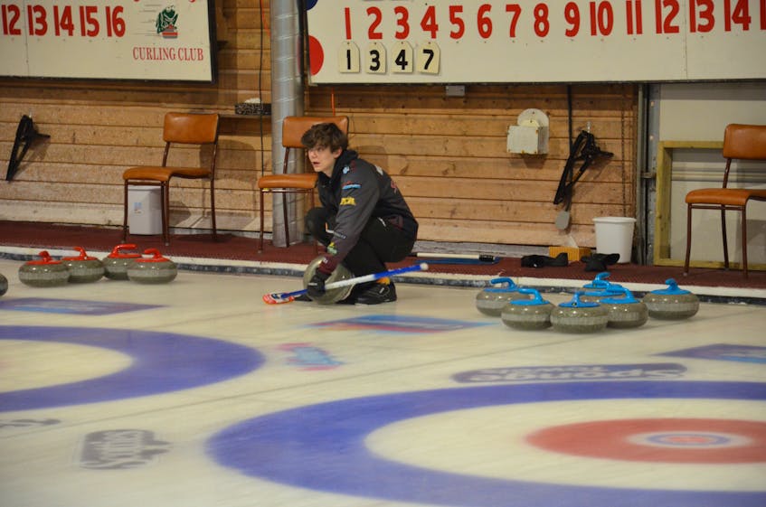Davis Nicholson cleans a rock before making a shot during the 2023 Pepsi P.E.I. under-21 curling championships at the Crapaud Community Curling Club in January. Nicholson is playing second stone with P.E.I.’s Brayden Snow rink at the 2023 Canada Winter Games in Prince Edward Island this week. Jason Simmonds • The Guardian