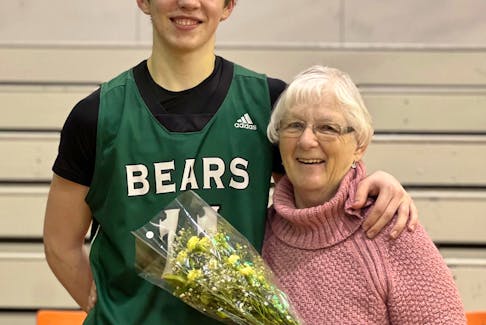 BEC Bears player Ben Kearney, left, presents longtime New Waterford Coal Bowl Classic fan Marjorie Wilson with flowers on Friday. PHOTO CONTRIBUTED/COAL BOWL CLASSIC.