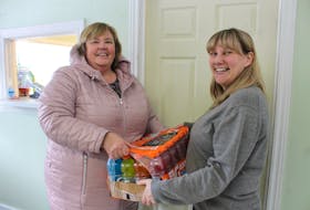 Shauna Wilcox of Glace Bay hands a case of Gatorade to Town House executive director Patti McDonald on Friday, a donation for the warming centre. NICOLE SULLIVAN/CAPE BRETON POST