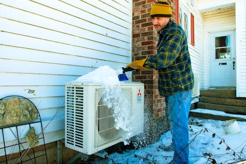 Greg Levy, owner of GForce Mechanical Inc., brushes snow from one of the heat pumps at his Hammonds Plains home on Friday, Feb. 3, 2023.
Ryan Taplin - The Chronicle Herald