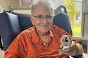  Steve Whitzman, now 72, shows off an Expos medallion from his extensive collection.