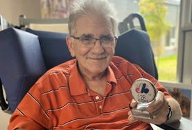  Steve Whitzman, now 72, shows off an Expos medallion from his extensive collection.