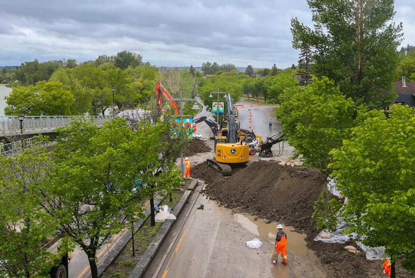  City of Calgary crews build an earth berm across Memorial Drive as flood protection on Tuesday, June 14, 2022.