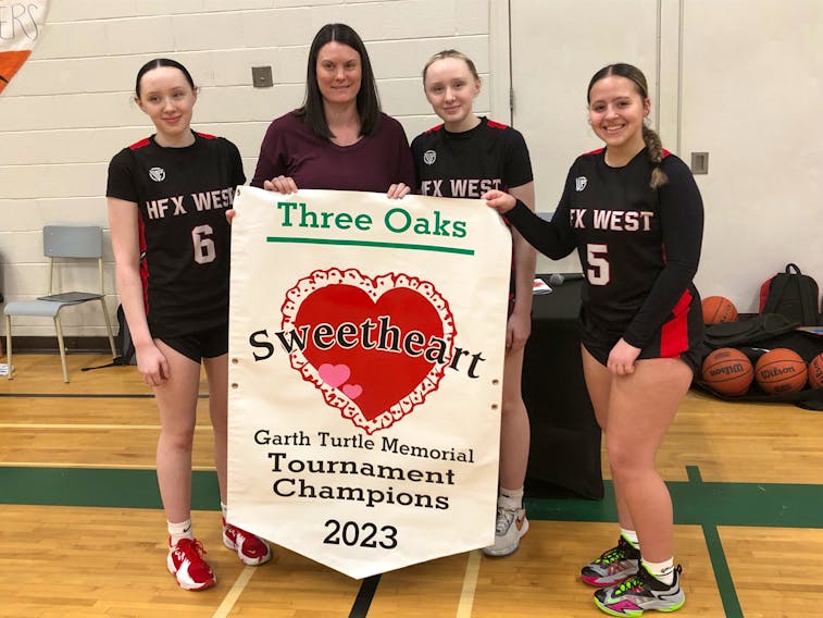 Kristen Turtle, second left, presented the championship banner for the Garth Turtle Memorial Sweetheart basketball tournament to the captains of the Halifax West Warriors, from left, Emma Cameron, tournament most valuable player Mya Cameron and Jayah Sapp. Halifax West defeated Parkview Educational Centre 81-44 in an all-Nova Scotia final of the senior AAA girls’ event in Summerside on Feb. 4. Turtle, a resident of Halifax, is the daughter of Garth Turtle and a former basketball player at host Three Oaks Senior High School. Jason Simmonds • The Guardian