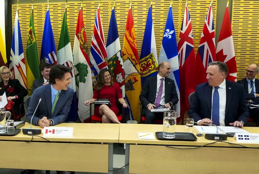 Quebec Premier Francois Legault sits beside Prime Minister Justin Trudeau as Canada's premiers meet in Ottawa on Tuesday, Feb. 7, 2023 in Ottawa. Minister of Finance Chrystia Freeland and Minister of Health Jean-Yves Duclos sit behind.