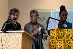 Black Loyalist Heritage Center executive director Andrea Davis holds up a framed copy of a proclamation made by the Municipality of Shelburne while Darlene Cooper, president of the Black Loyalist Heritage Society applauds during the African Heritage Month Proclamation launch on Feb. 1 at the Black Loyalist Heritage Centre. The proclamation was presented by Warden Penny Smith. KATHY JOHNSON