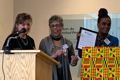 Black Loyalist Heritage Center executive director Andrea Davis holds up a framed copy of a proclamation made by the Municipality of Shelburne while Darlene Cooper, president of the Black Loyalist Heritage Society applauds during the African Heritage Month Proclamation launch on Feb. 1 at the Black Loyalist Heritage Centre. The proclamation was presented by Warden Penny Smith. KATHY JOHNSON
