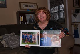 Germaine Fisher sits with a photo album of her family. When her husband Peter, a chemistry professor for much of his life, recovered from a bladder infection that nearly killed him in 2019, she was determined to take care of him at home, despite the many healthcare professionals who insisted she would be unable to manage it. Andrew Waterman/The Telegram