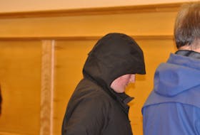 Noelle Laite leaves provincial court in Corner Brook with her head covered by the hood on her coat on Tuesday, Feb. 28. - Diane Crocker/SaltWire Network