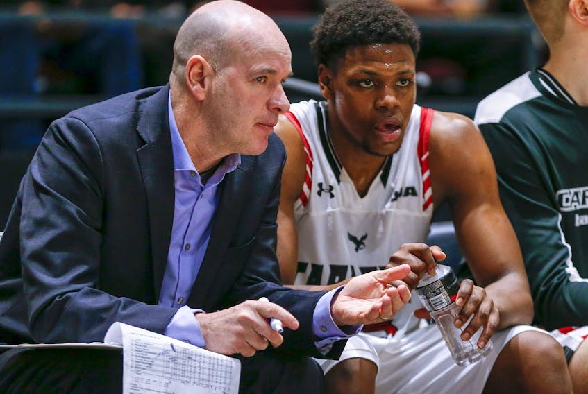  Former head coach Dave Smart chats with Alain Louis on the bench as the Carleton Ravens take on the Calgary Dinos during the quarter-finals of the 2020 U SPORTS Final 8 Championships at TD Place in Ottawa.