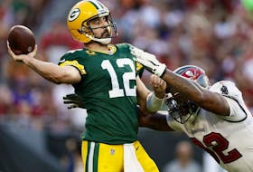 Aaron Rodgers of the Green Bay Packers throws a pass with pressure from William Gholston of the Tampa Bay Buccaneers during the fourth quarter in the game at Raymond James Stadium on September 25, 2022 in Tampa, Florida.
