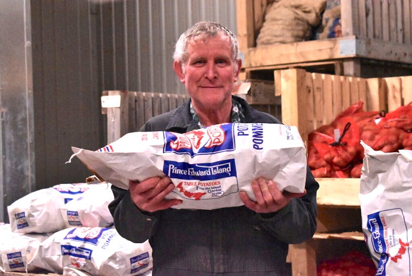 John Cummiskey, a field operator at Agriculture and AgriFood Canada's Harrington research farm, holds up a bag of potatoes he and his team harvested in the fall. The spuds are grown like regular table potatoes and the farm saved 10,000 pounds to donate to food banks, when and if needed.