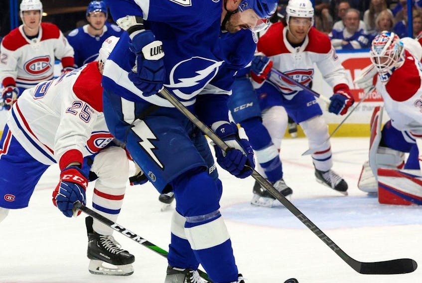 Tampa Bay Lightning forward Alex Killorn tries to control puck while being checked by the Canadiens’ Denis Gurianov during first-period action Saturday night at Amalie Arena.