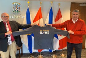 Dr. Robert Strang, left, and former premier Stephen McNeil hold the Stay the Blazes Home shirt which is being auctioned off online for the Seaview Manor Seniors Foundation. Contributed
