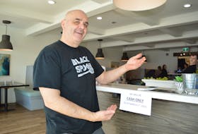 Mike Black, owner of the Black Spoon Bistro in North Sydney displays the cash only sign now at the front of the restaurant. The bistro switched to cash-only this week. GREG MCNEIL/CAPE BRETON POST