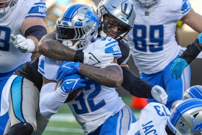 Dec 24, 2022; Charlotte, North Carolina, USA; Detroit Lions running back D'Andre Swift (32) is tackled by Carolina Panthers linebacker Frankie Luvu (49) during the second half at Bank of America Stadium.  