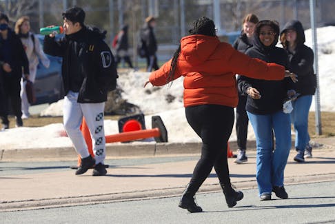 A woman prepares to embrace a teenager who had just left C.P. Allen high school in Bedford Monday, after a stabbing earlier in the morning injured two staff members. on Monday March 20, 2023

TIM KROCHAK PHOTO