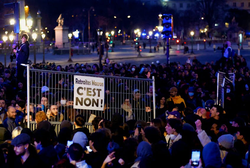 Protesters hold a barricade as they attend a demonstration in front of National Assembly on Place de la Concorde to protest the use by French government of the article 49.3, a special clause in the French Constitution, to push the pensions reform bill through the National Assembly without a vote by lawmakers, in Paris, France, March 17, 2023. REUTERS/Gonzalo Fuentes  Protesters hold a barricade at a demonstration in front of National Assembly on Place de la Concorde to protest the government's plan to raise the retirement age.  REUTERS/Gonzalo Fuentes