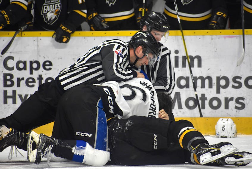 Linesmen Dave Ivey, right, and Stephen Clarke break up a fight during recent Quebec Major Junior Hockey League action at Centre 200 in Sydney. The league is expected to ban fighting beginning in the 2023-24 season. JEREMY FRASER/CAPE BRETON POST