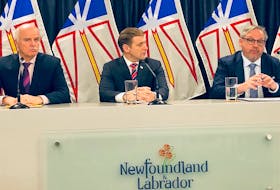 NLMA president Dr Kris Luscombe (right) explains how a blended capitation payment model will encourage family physicians to form team-based clinics. Looking on are Health Minister Tom Osborne (left) and Premier Andrew Furey. Peter Jackson • The Telegram