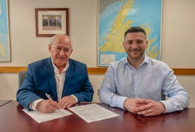 Qalipu Holdings LP CEO John Davis, left, signs a memorandum of understanding with EVREC CEO J. Colter Eadie. Contributed