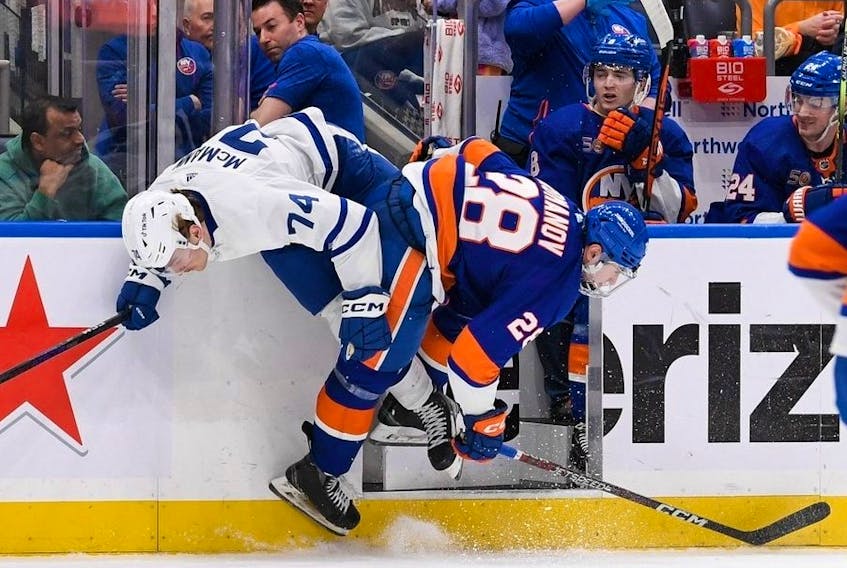 Mar 21, 2023; Elmont, New York, USA; New York Islanders defenseman Alexander Romanov (28) checks Toronto Maple Leafs center Bobby McMann (74)  during the third period at UBS Arena.  