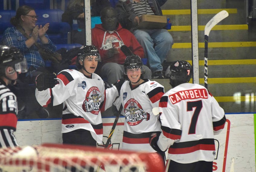 Ben Mercer, left, celebrates the first of his two goals during the Pictou County Crusher's home opener along with teammates Leyton Stewart and Venel Campbell. - FILE PHOTO