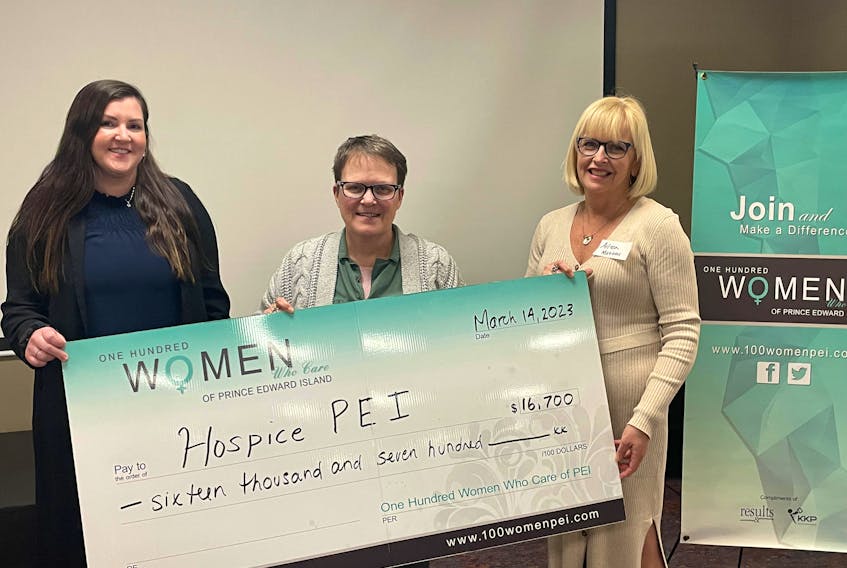 Jackie Phelan, left, and Aileen Matters, right, of the 100 Women Who Care organizing committee, present Nancymarie Arsenault, executive director of Hospice P.E.I., with a  $16,700 donation. Contributed