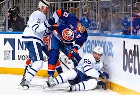  Justin Holl and Mark Giordano of the Toronto Maple Leafs defend against Anders Lee of the New York Islanders during the second period at the UBS Arena on March 21, 2023 in Elmont, New York.