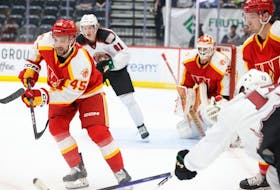 Calder Brooks, left, is trying to make a positive impression during a call-up with the American Hockey League’s Calgary Wranglers. 