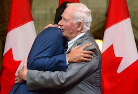 Governor General David Johnston, right, hugs Prime Minister Justin Trudeau  during a reception in Ottawa in 2017.