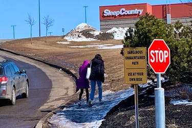Walkers make their way up the hill alongside Buchanan Drive in Charlottetown. The company that owns the shopping centres also owns the road and told SaltWire Network it has plans to install a paved pathway in late June. Terrence MacEachern • The Guardian