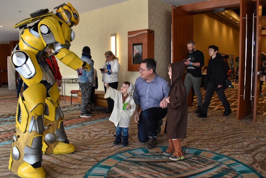 Alden Burke as Bumblebee, left, fist-bumps Elliot O'Brien Simard, a young padawan, while dad, Justin Simard, and brother Charlie O'Brien Simard as Obi-Wan, wait their turn. Alison Jenkins • The Guardian