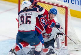 Canadiens' Rafaël Harvey-Pinard battles Blue Jackets' Kirill Marchenko in front of goaltender Elvis Merzlikins Saturday night at the Bell Centre.