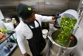 Paul Hill drops in a bowl of chopped green onion as he begins to make a batch of Hills Jamaican BBQ sauce, at their facilty in Harrietsfield Monday March 27, 2023.

TIM KROCHAK PHOTO
