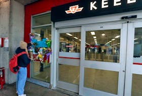 A woman places flowers at a makeshift memorial at the TTC's Keele subway station for Gabriel Magalhaes, who was stabbed to death two days earlier in an unprovoked attack, March 27, 2023.