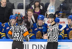 Edmonton Oil Kings head coach Luke Pierce converses with officials in a game against the Swift Current Broncos at Rogers Place in Edmonton on Dec. 16, 2022. The Broncos won 8-4.