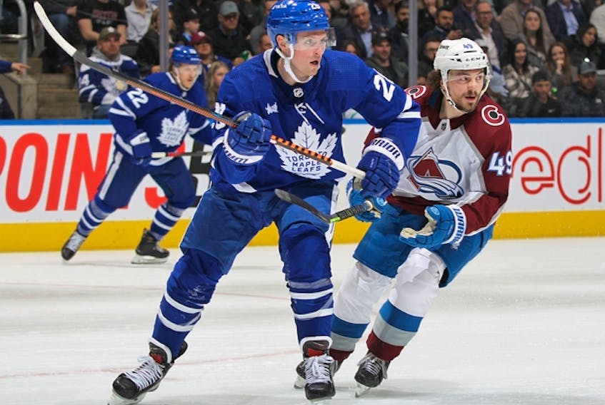 Sam Lafferty (left) skates against the Colorado Avalanche. The Maple Leafs winger's wife, Madison, is due to give birth in the next couple of weeks.