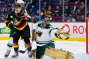 Minnesota Wild goalie Marc-Andre Fleury  makes a save as Vancouver Canucks forward Sheldon Dries  battles with defenceman Matt Dumba  in the first period at Rogers Arena March 2, 2023. 