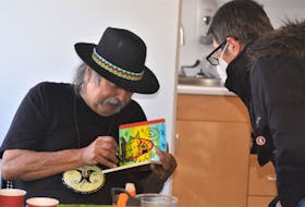 Millbrook First Nation artist Alan Syliboy chats with folks while signing a book of his work for them, during an event at the Colchester East Hants Regional Library on Feb. 25. Richard MacKenzie