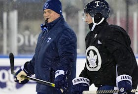 Head coach Sheldon Keefe of the Toronto Maple Leafs skates with Travis Dermott #23 during family skate at Tim Hortons Field on March 12, 2022 in Hamilton, Ontario.
