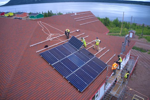 Workers installing solar panels on the roof of the Community Centre in Rigolet, N.L. The system was installed by nine local residents as part of the Community Solar Skills Training program offered by Iron & Earth. PHOTO CREDIT: Iron & Earth