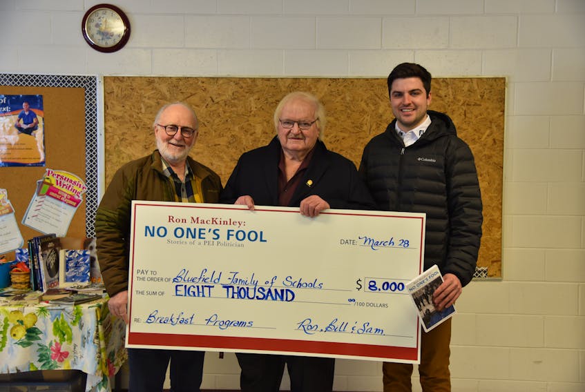 Ron MacKinley: No One's Fool co-author Bill Hogg, left, Ron MacKinley and co-author Sam MacPhail hold the $8,000 cheque for the Bluefield family of schools breakfast programs. Contributed