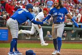Blue Jays shortstop Bo Bichette (11) and right fielder George Springer (4) celebrate after they scored against the St. Louis Cardinals during the eighth inning at Busch Stadium. 