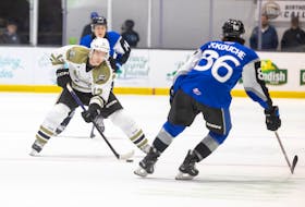 Charlottetown Islanders forward and team captain Keiran Gallant, 12, goes 1-on-1 against Saint John Sea Dogs defenceman Danny Akkouche, 86, in a Quebec Major Junior Hockey League (QMJHL) at Eastlink Centre in Charlottetown on March 24. The Sea Dogs’ Alex Drover, 14, back-checks on the play. Gallant, a 13th-round draft pick from Covehead, is in his fourth and final season with the Islanders. Darrell Theriault Photo • Courtesy of Charlottetown Islanders