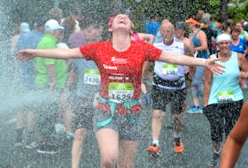 It's a great sense of personal accomplishment to take part in The Tely 10 Mile Road Race. Runners cool down as they pass through the water of a hose on Topsail Road in this Tely 10 file photo. — Keith Gosse/The Telegram