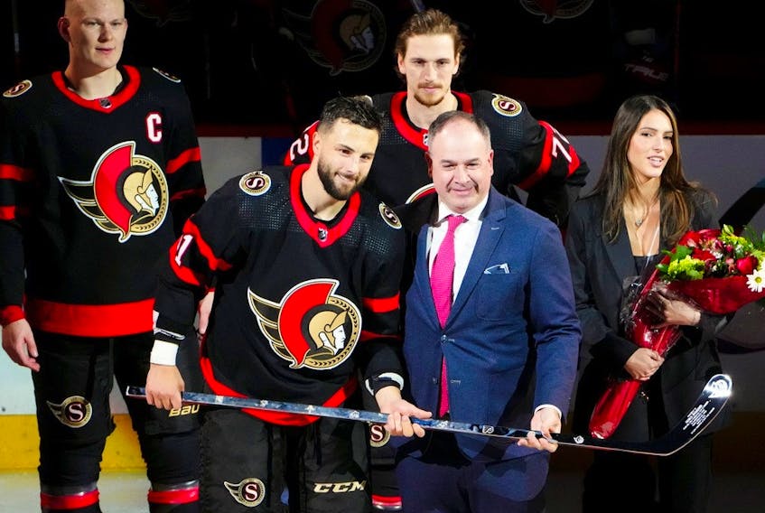  Senators general manager Pierre Dorion presents Senators centre Derick Brassard (61) with a silver stick for reaching 1000 games played in the NHL prior to taking on the Blue Jackets on Saturday.