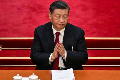 China's President Xi Jinping applauds during the opening session of the National People's Congress (NPC) at the Great Hall of the People in Beijing on March 5, 2023. (Photo by NOEL CELIS / AFP) 