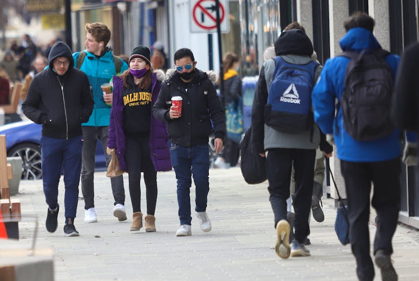 An array of mast and unmasked pedestrians are seeing on Spring Garden Road in Halifax Tuesday, March 22, 2022